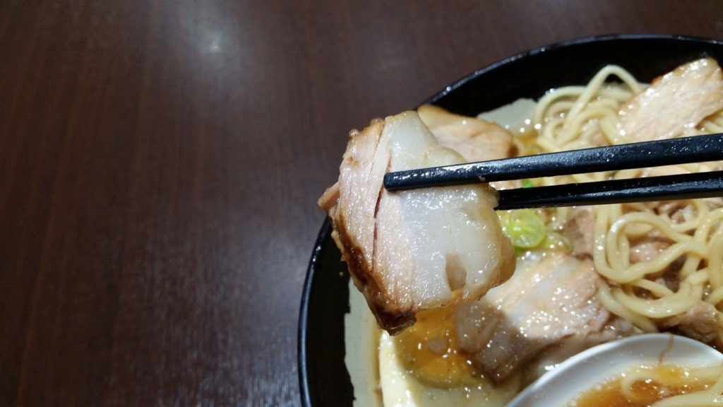 大塚『北大塚ラーメン』のチャーシュー麺のチャーシューを、箸で持ち上げた写真