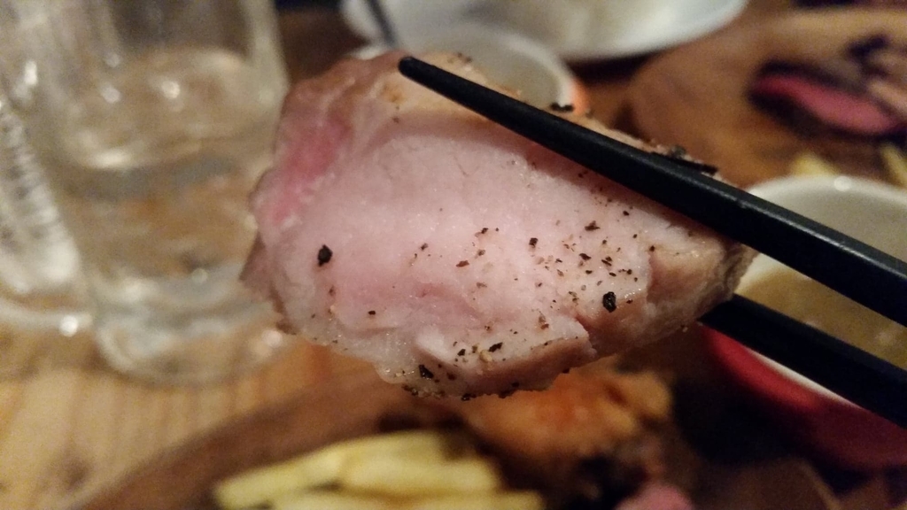 箸で掴んだ豚ロースステーキ