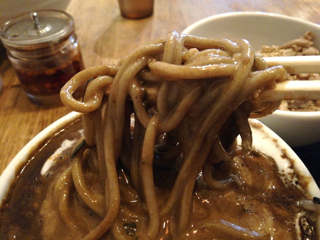 黒カレーを絡めた麺のアップ