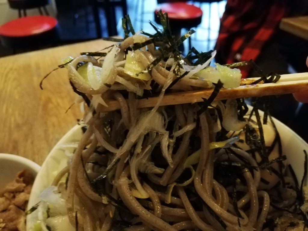 箸で持ち上げた麺とネギと海苔のアップ