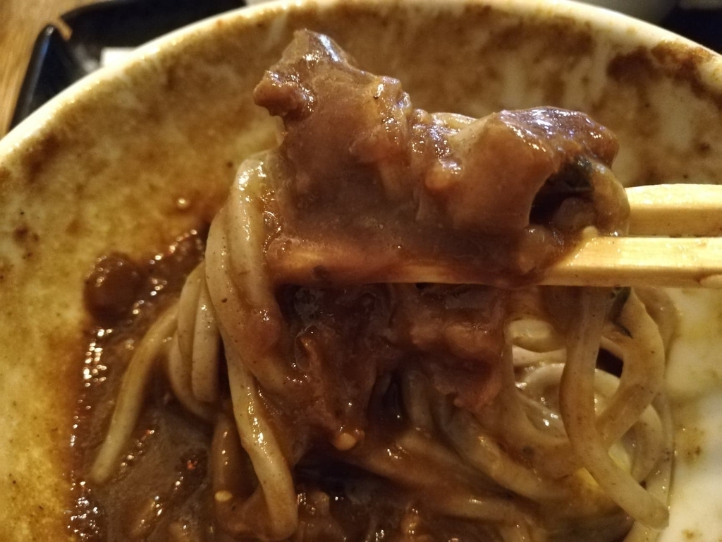 麺に絡めた肉と黒カレー