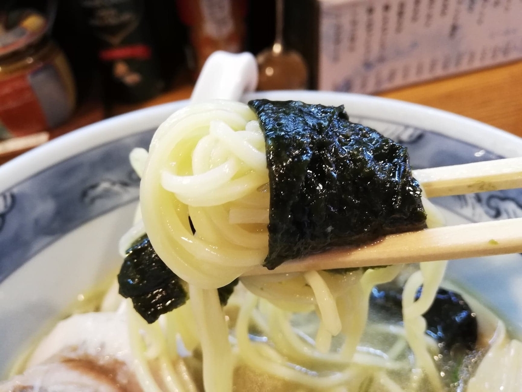 箸で掴んだ特選塩ラーメンの麺と海苔