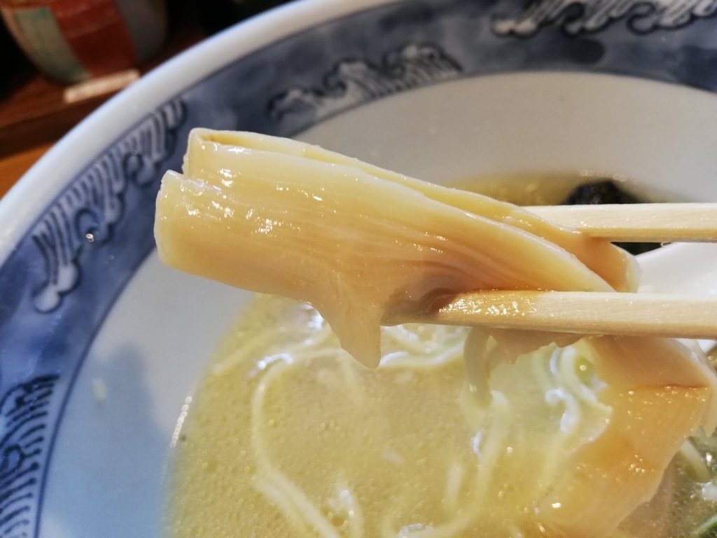 箸で掴んだ特選塩ラーメンのメンマ