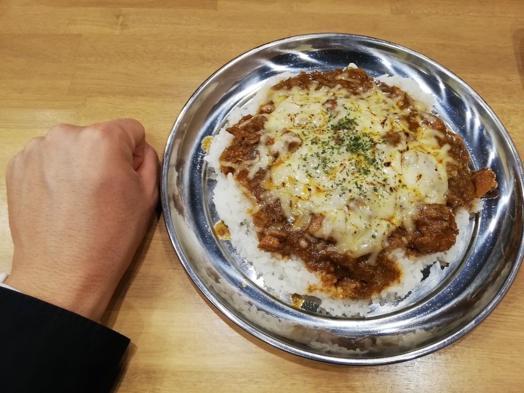 高田馬場『プネウマカレー』のチキンカレーと拳のサイズ比較