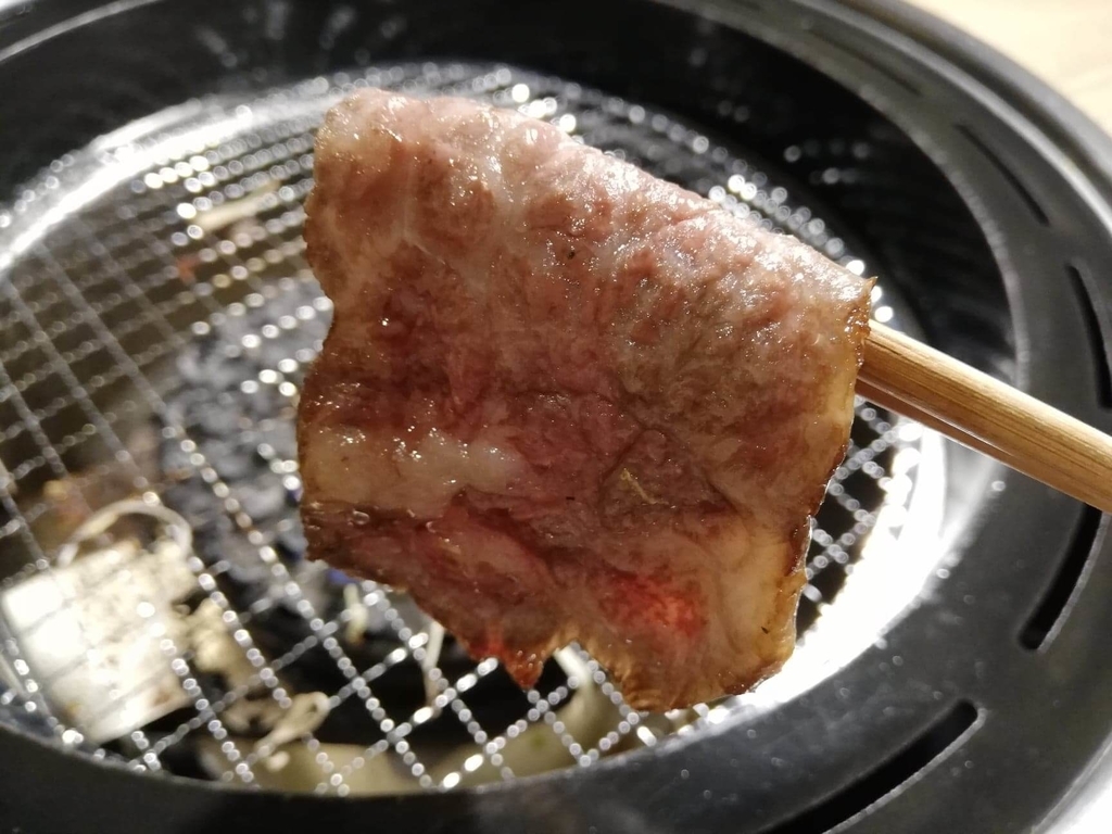 浅草焼肉たん鬼『鬼く丼』のお肉を焼いて箸で掴んだ写真