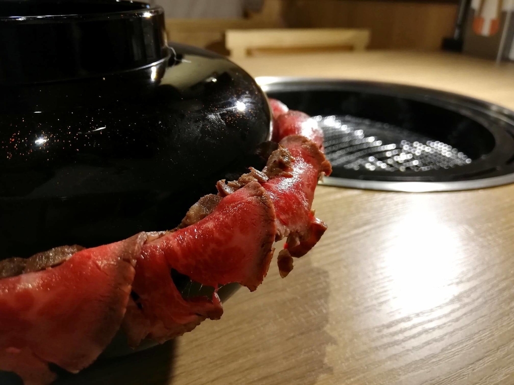 浅草焼肉たん鬼『鬼く丼』のお椀からお肉がはみ出ている写真