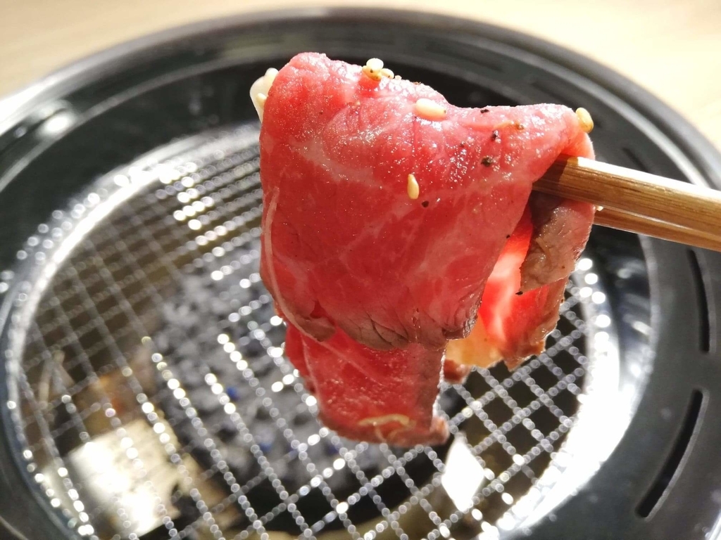 浅草焼肉たん鬼『鬼く丼』の焼いていないお肉を、箸で掴んだ写真