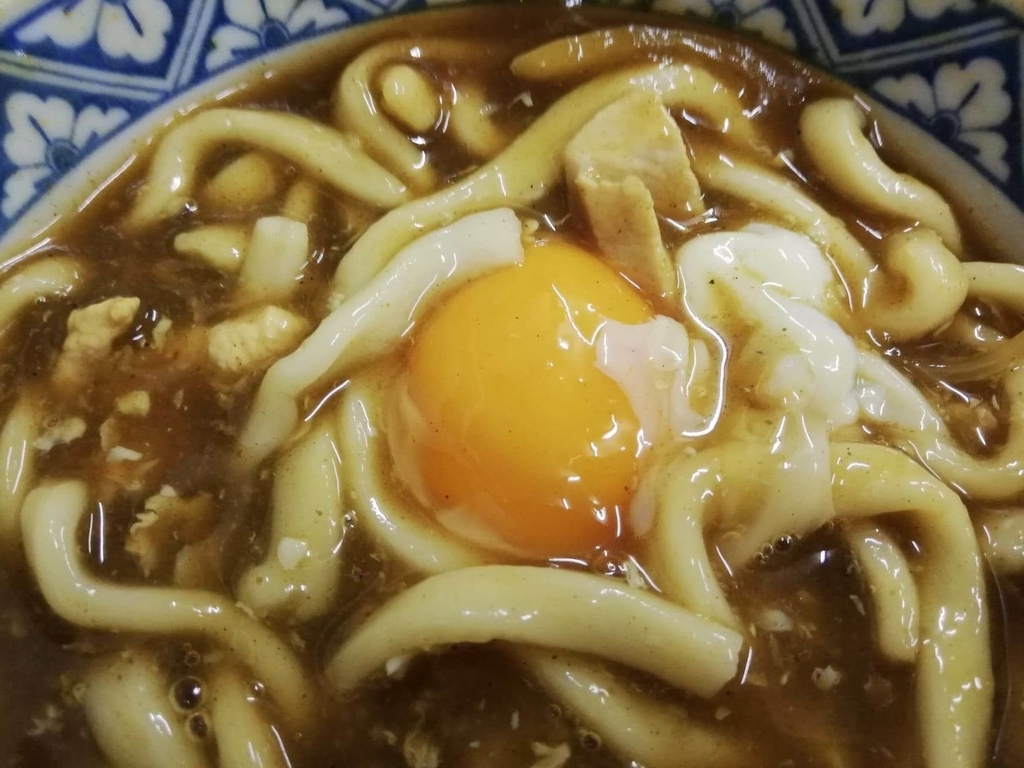 浅草『翁そば』のカレー南蛮うどんに乗っている生卵のアップ