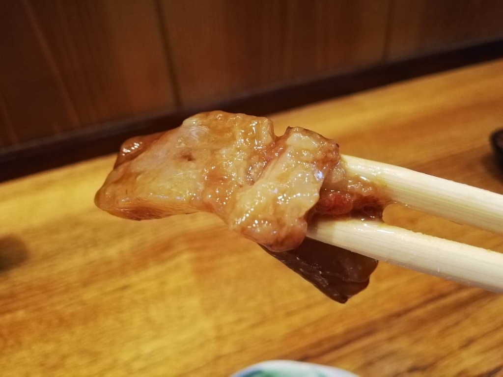 長崎『吉宗本店』の吉宗定食の、豚の角煮の脂身を箸で掴んだ写真