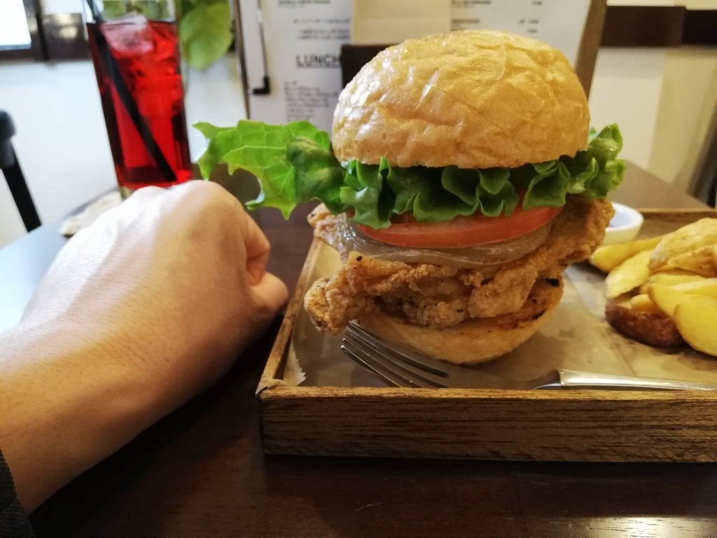 上野（御徒町）『ゴールデンゲート（GOLDEN GATE）』のフライドチキンバーガーと拳のサイズ比較写真