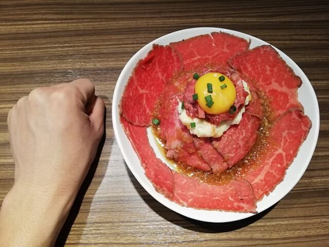 新宿『焼肉ブルズ』の特選和牛のローストビーフ丼と拳のサイズ比較