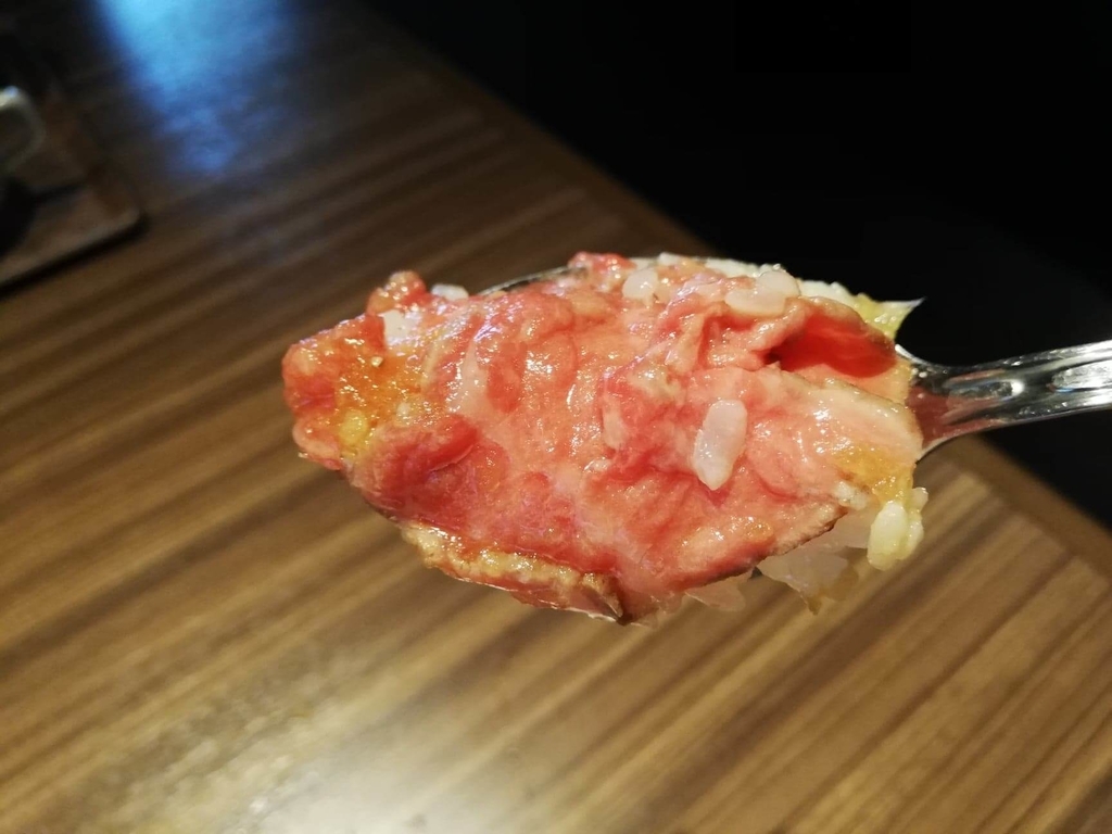新宿『焼肉ブルズ』の特選和牛のローストビーフ丼のお肉をスプーンですくった写真