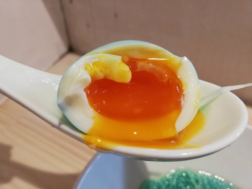 渋谷『吉法師』の『鶏清湯 青』に乗っている半熟卵の写真