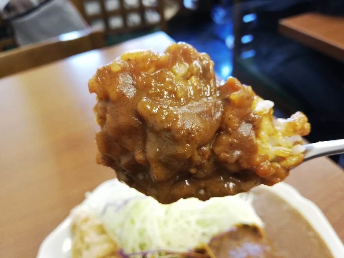 池袋『とんかつ清水屋』のロースかつカレー定食をスプーンですくった写真