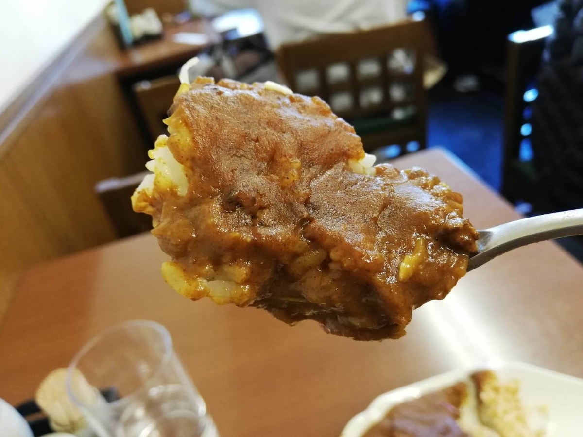 池袋『とんかつ清水屋』のロースかつカレー定食のロースカツとカレーを、一緒にすくった写真