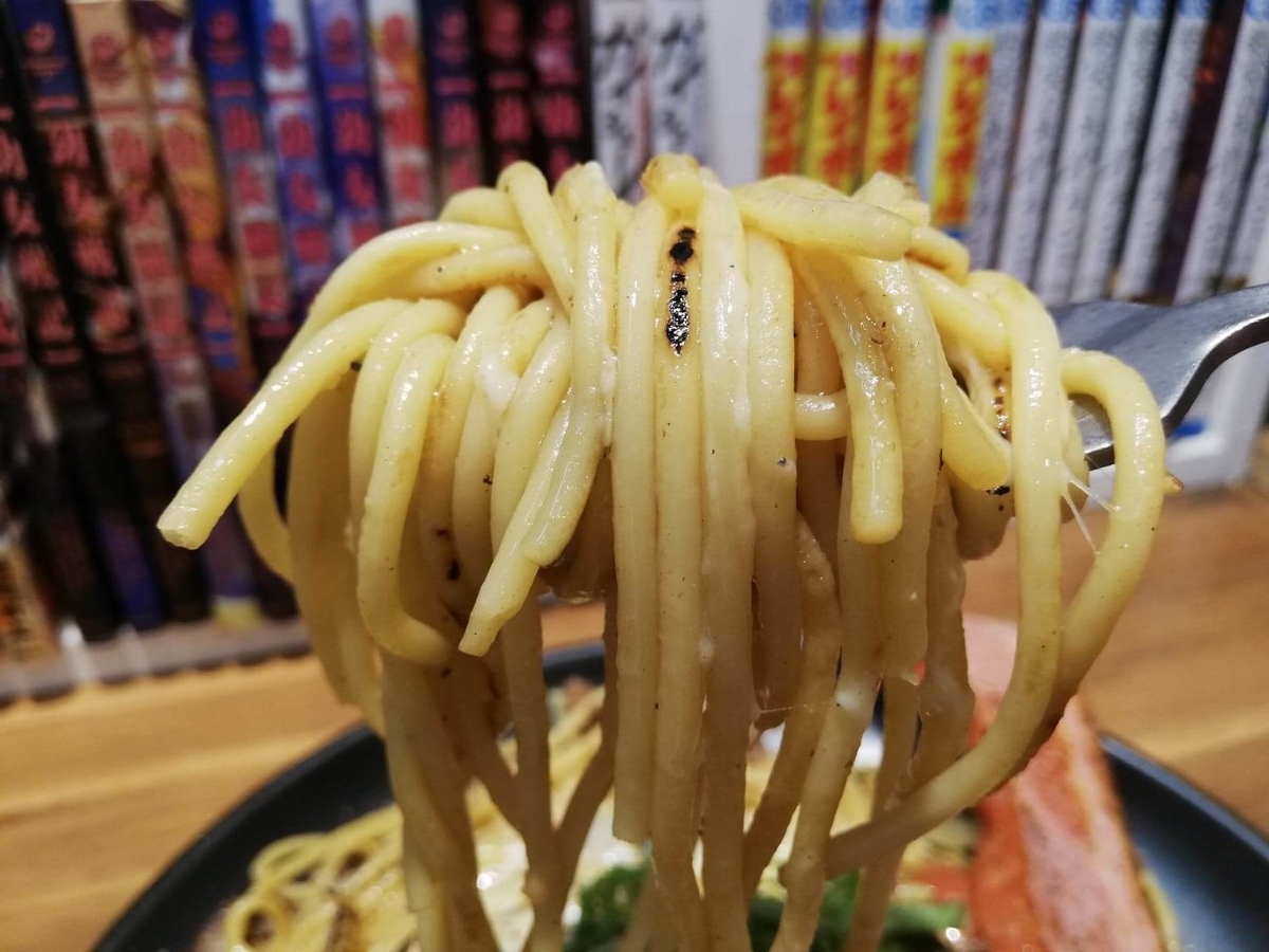 立川『スパゲッティPiaPia（ピアピア）』の、豚にんにくスパゲッティの麺をフォークですくっている写真