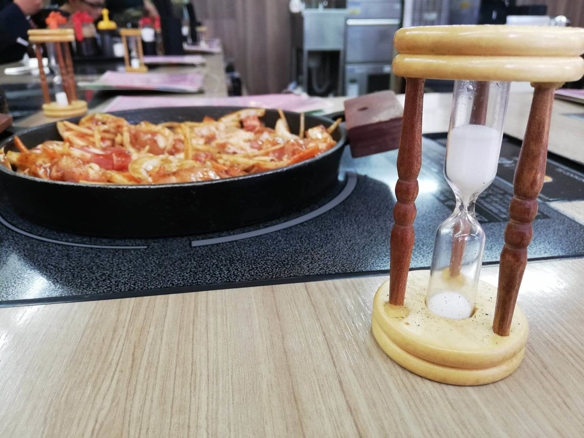 江古田『ふくふく食堂』のBBQ定食を、砂時計で測りながら焼いている写真