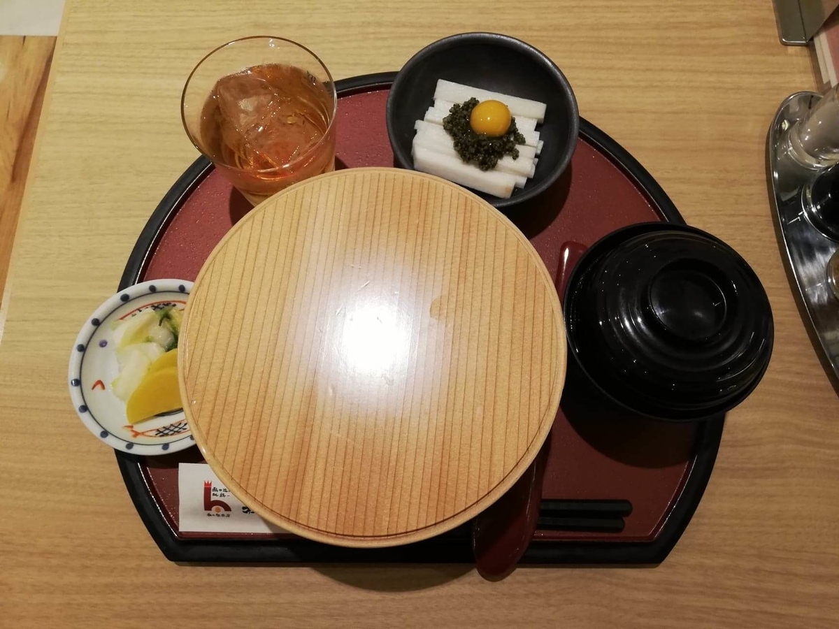 秋田駅『秋田比内地鶏や』の、比内地鶏の究極親子丼に蓋を被せた写真