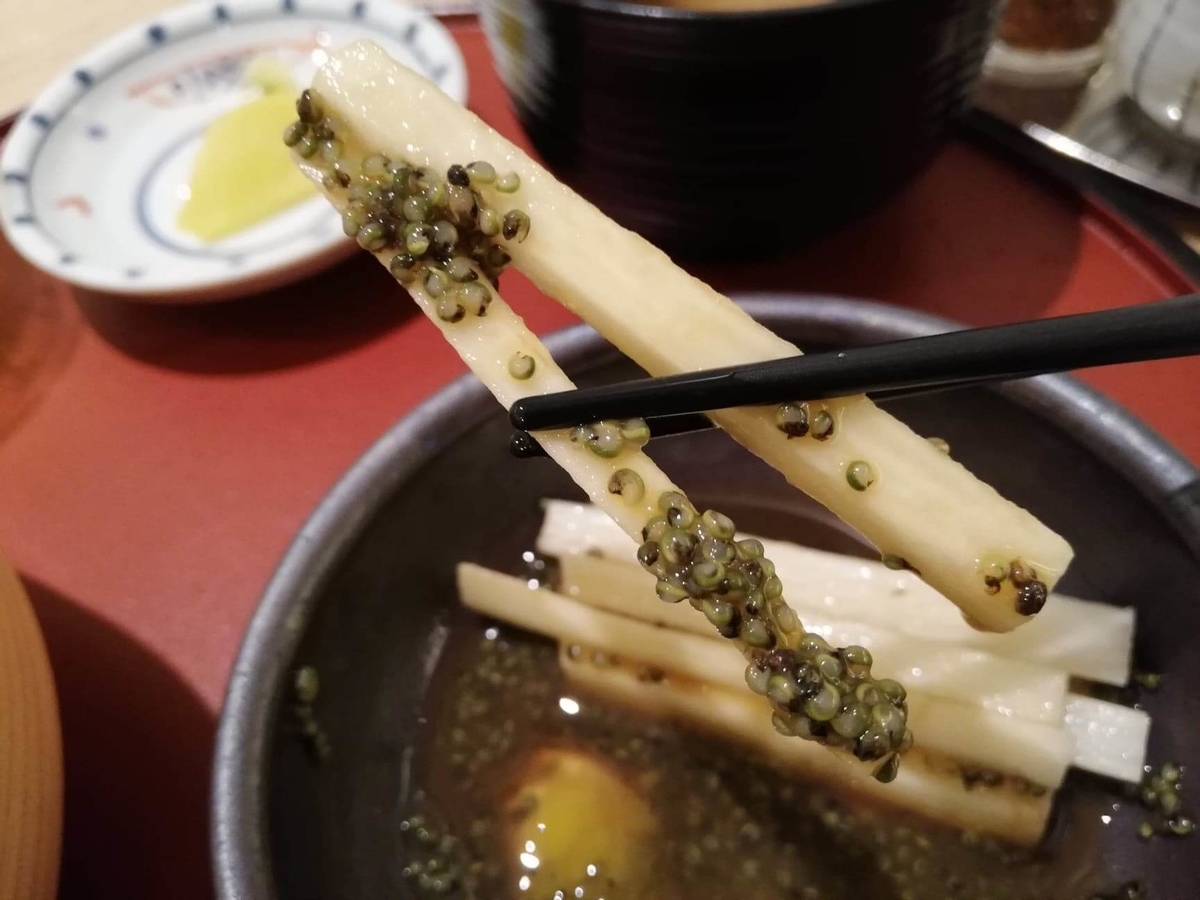 秋田駅『秋田比内地鶏や』の、長芋とんぶりを箸で掴んでいる写真