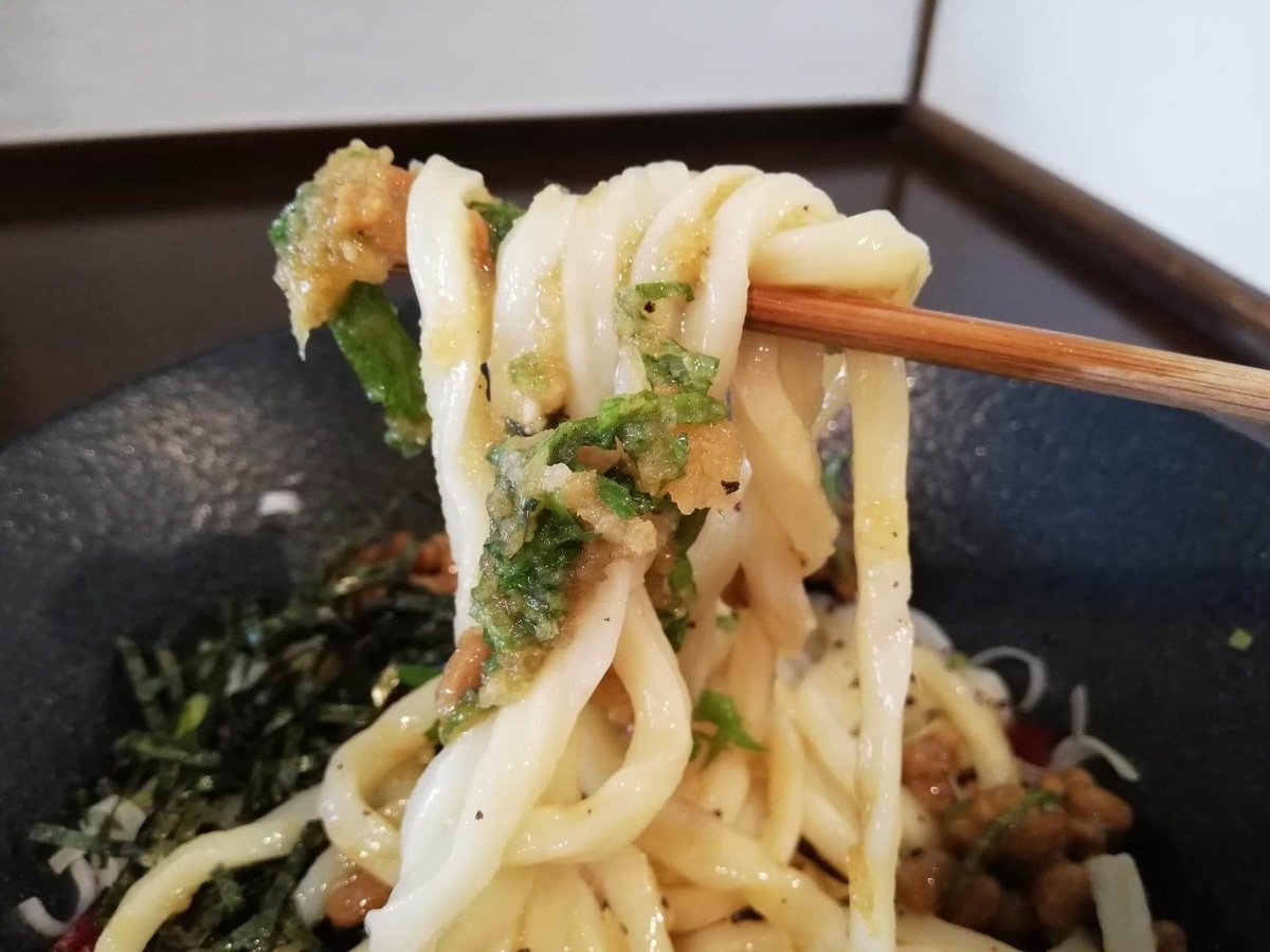 川越『創作うどん専門店くらうど』の、３種のしその納豆おろしうどんの麺を箸で持ち上げている写真