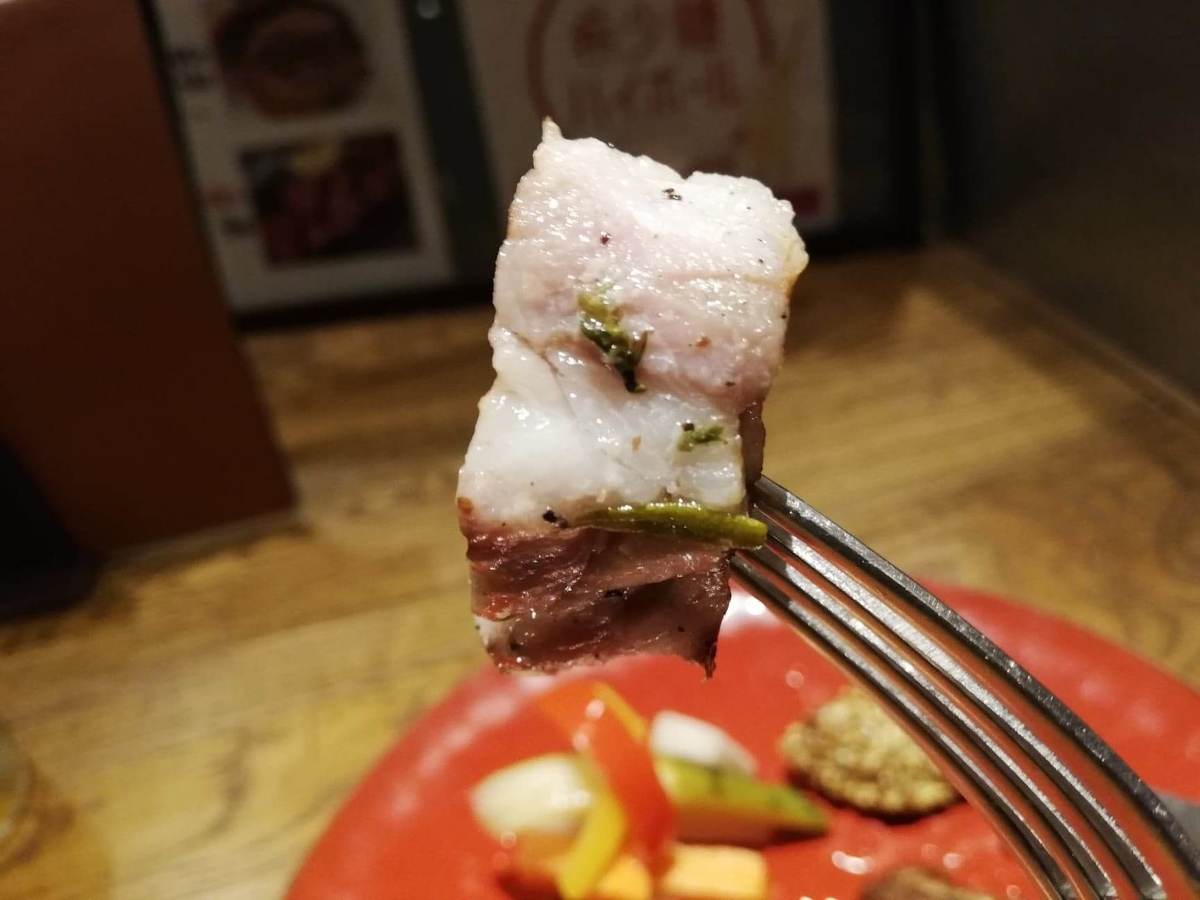 香川県高松市『瀬戸内豚料理紅い豚』のポルケッタを、フォークで持ち上げている写真