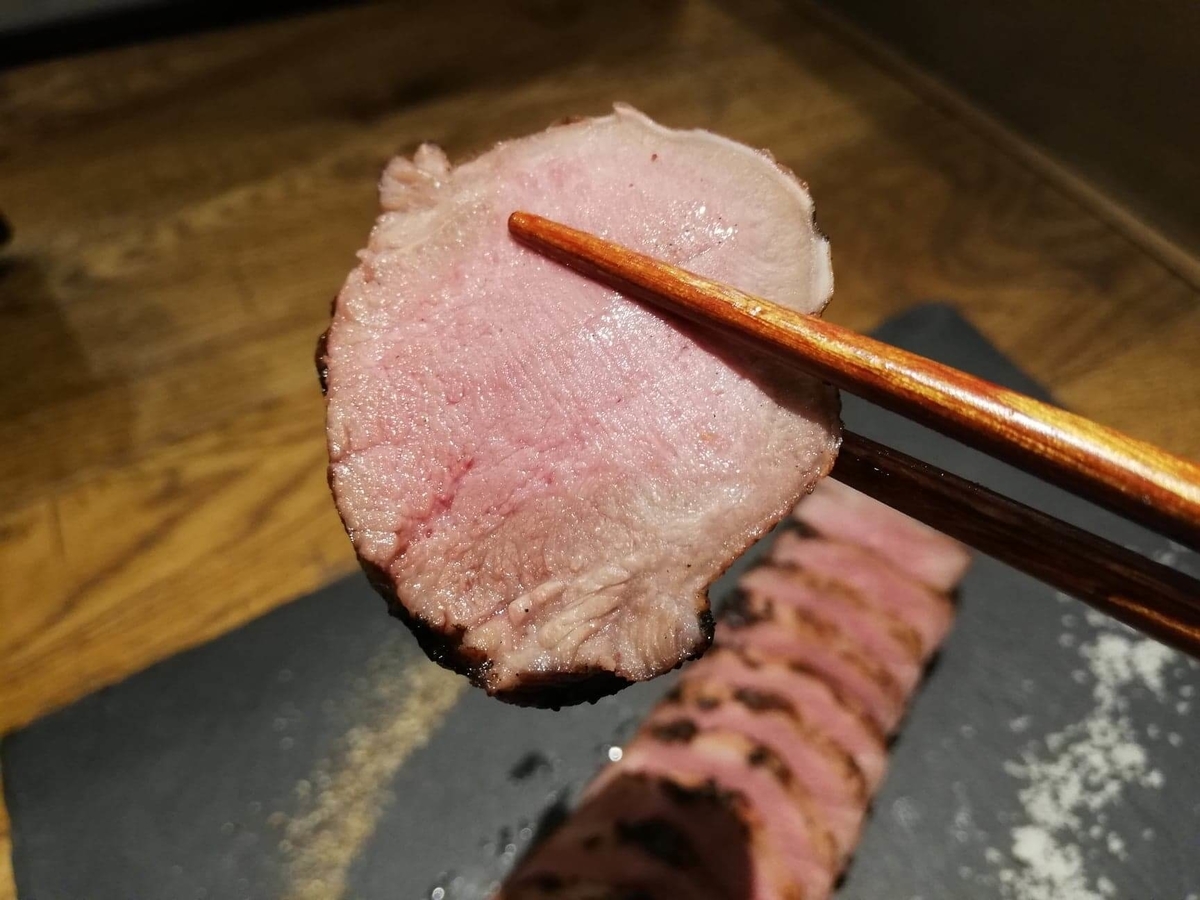 香川県高松市『瀬戸内豚料理紅い豚』の豚タンを箸で掴んでいる写真