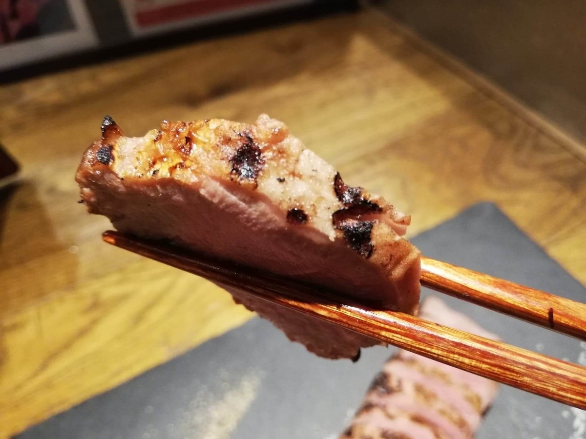 香川県高松市『瀬戸内豚料理紅い豚』の豚タンを箸で掴んでいる写真