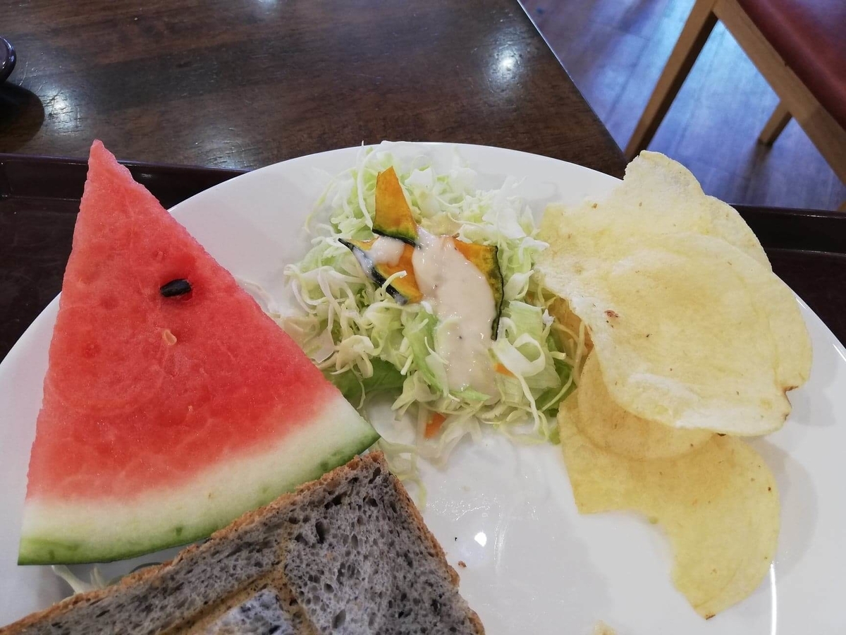 香川県高松市『三びきの子ぶた』のサラダとスイカとポテトチップスの写真