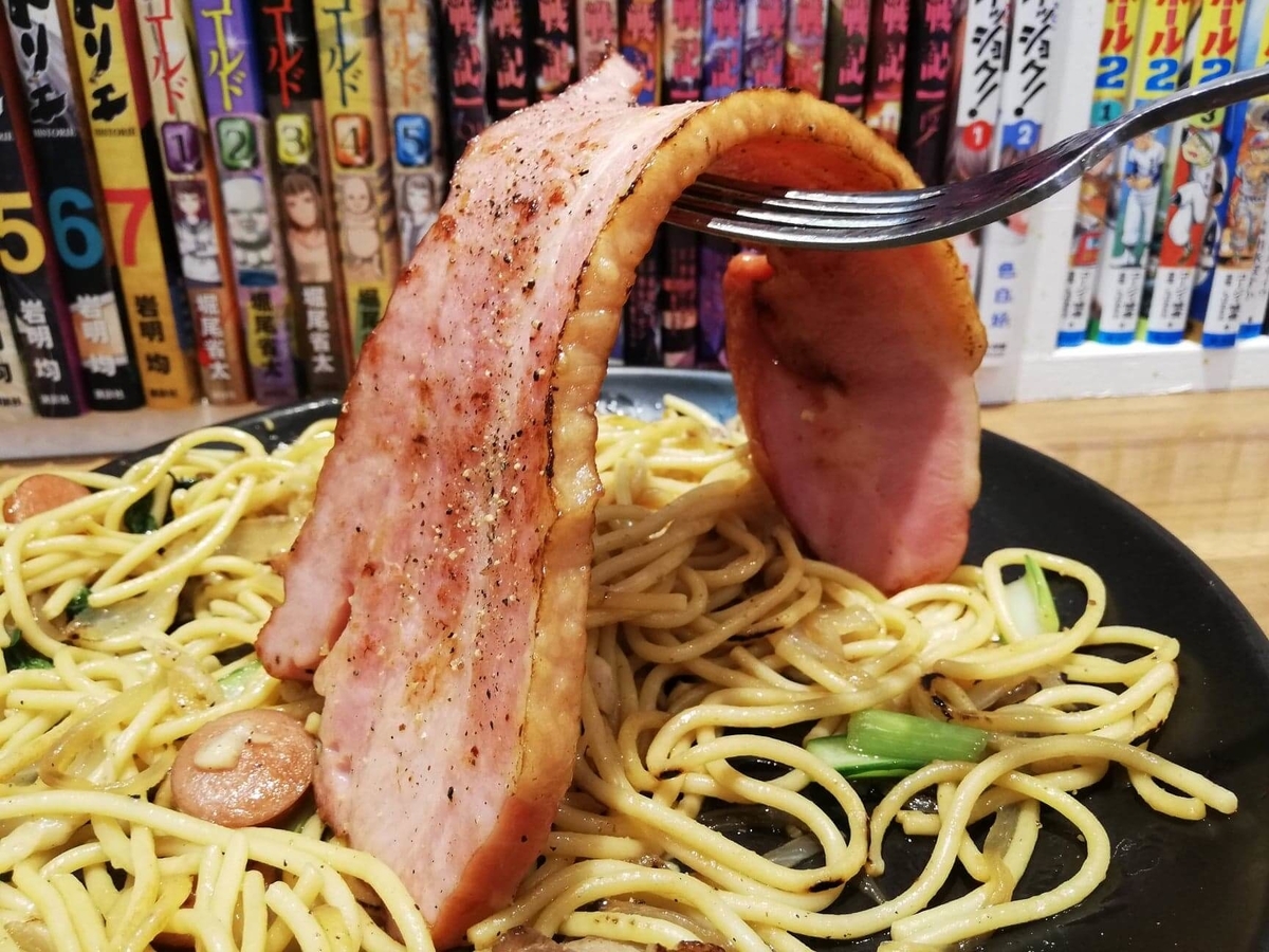 立川『スパゲッティPiaPia（ピアピア）』の、豚にんにくスパゲッティに乗っている厚切りベーコンのアップ写真