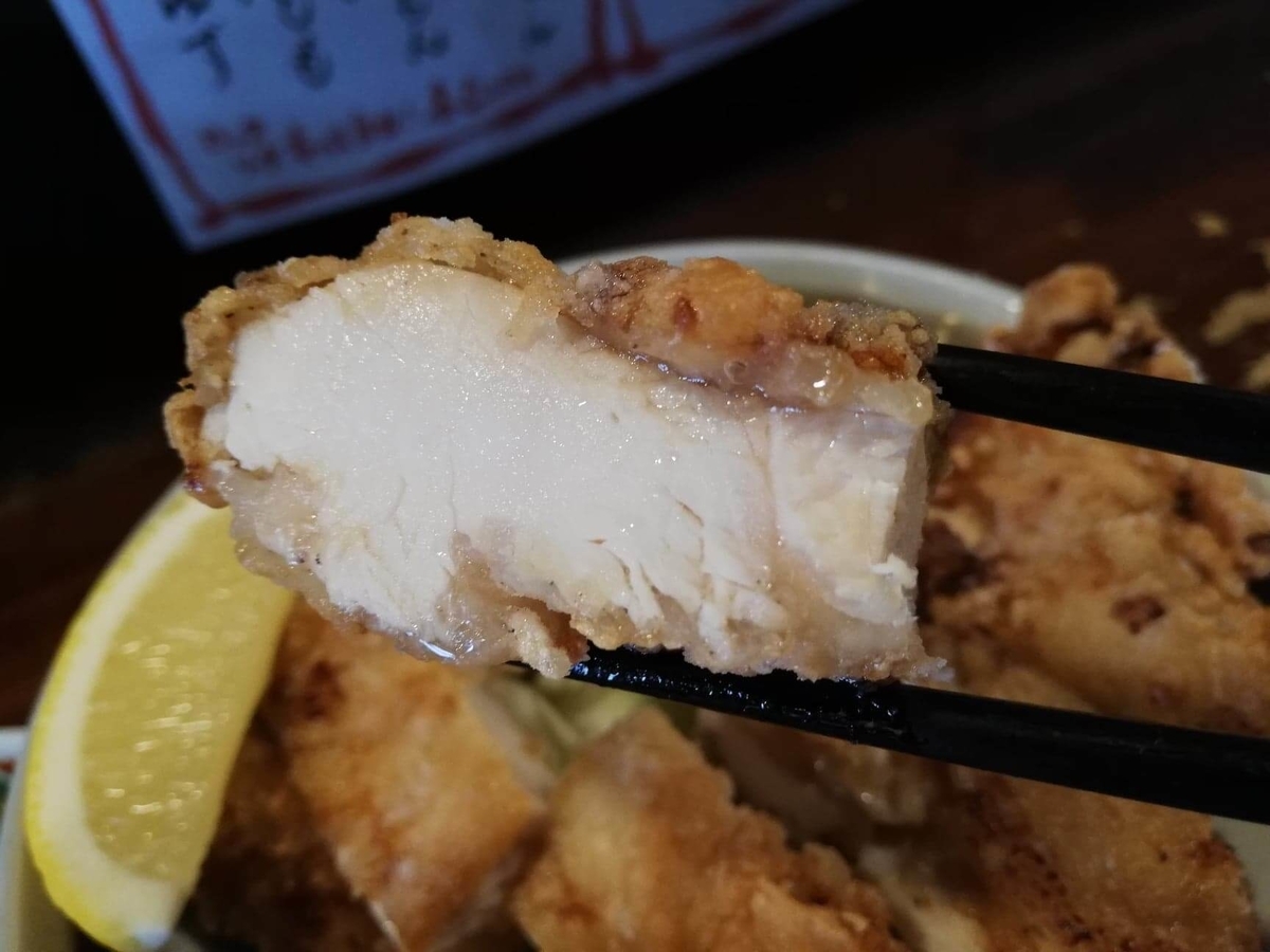 長野県松本市中町通り『食い飲み屋 BUN』の山賊焼きを箸で掴んでいる写真