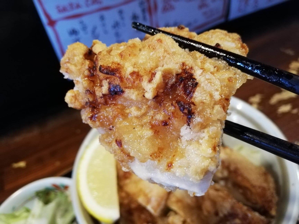 長野県松本市中町通り『食い飲み屋 BUN』の山賊焼きを箸で掴んでいる写真