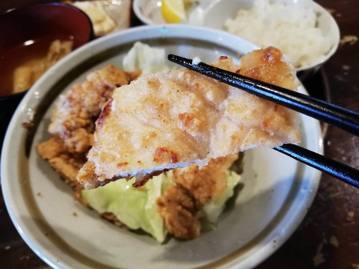 長野県松本市中町通り『食い飲み屋 BUN』の山賊焼きを箸で掴んでいる写真