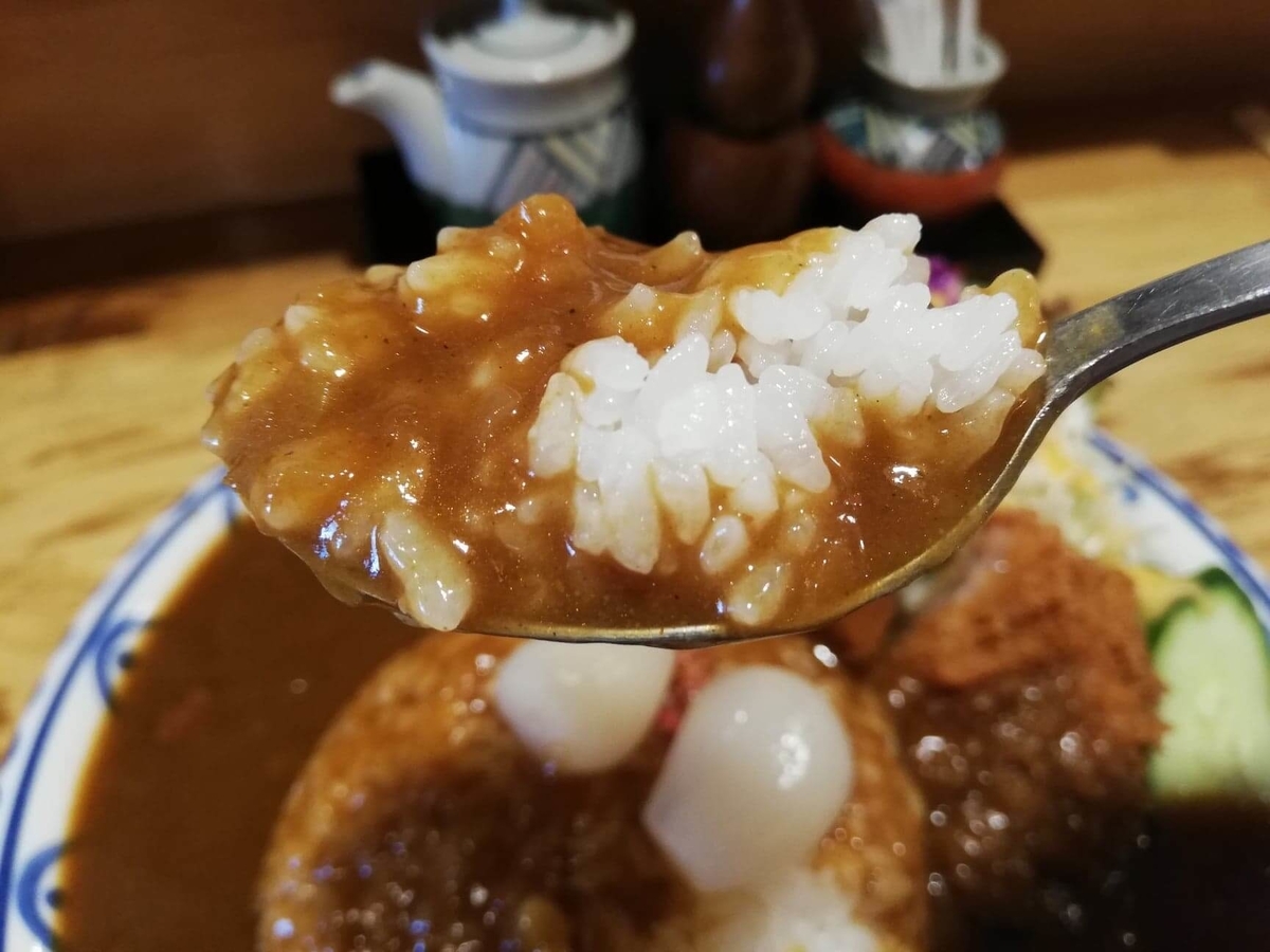 長野県松本市中町通り『松本くろ門』の牛すじカツカレーをスプーンですくっている写真