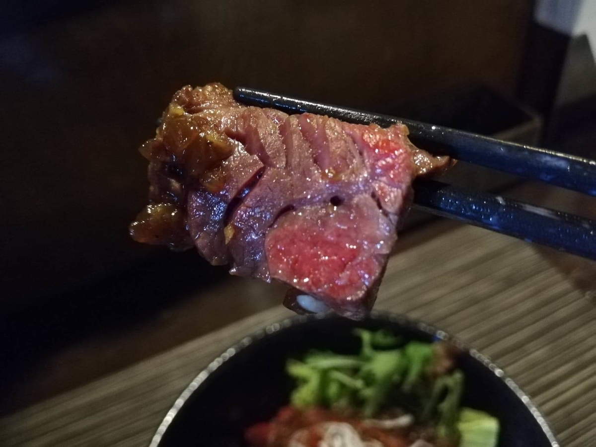 浦和『carnegico（カルネジコ）』の赤身ステーキを箸で持ち上げている写真