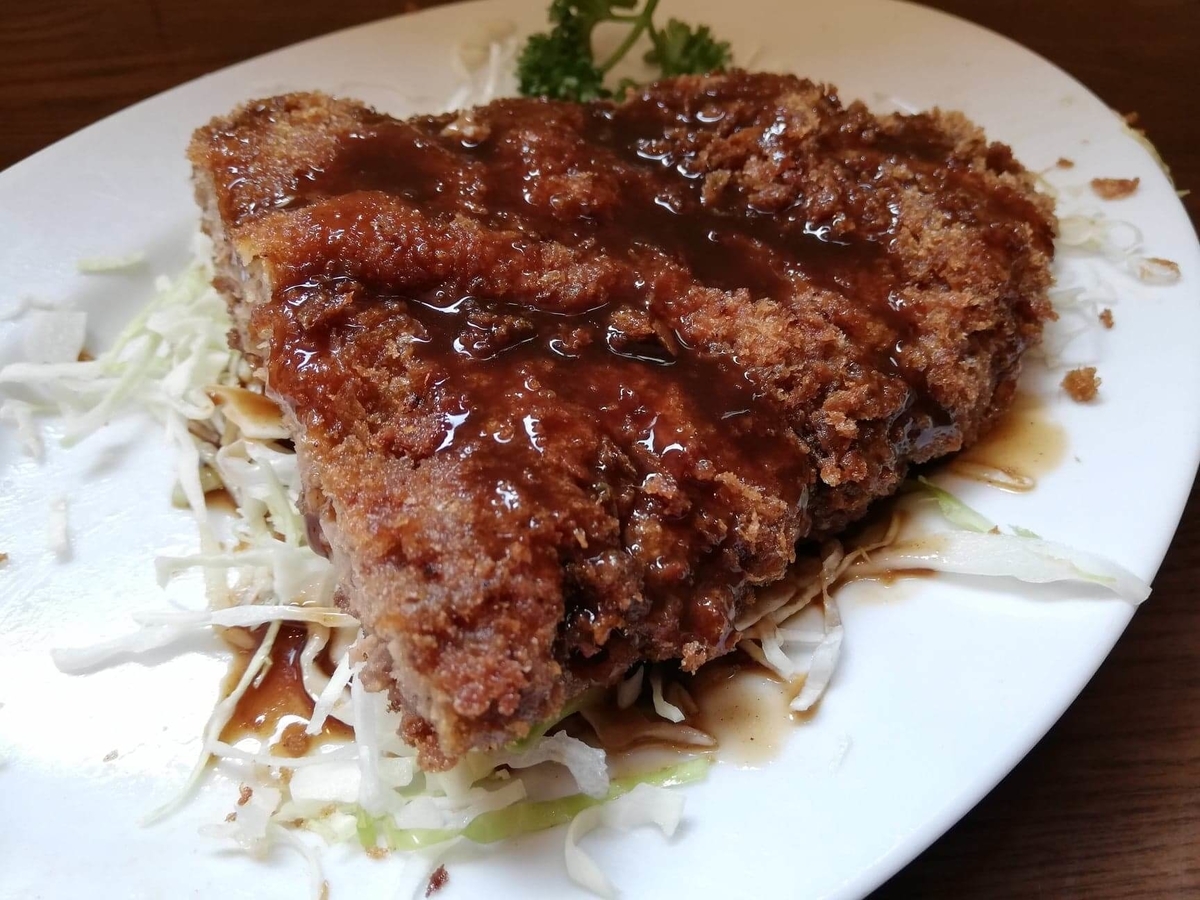 新橋（御成門）『洋食すいす』のメンチカツにソースをかけた写真