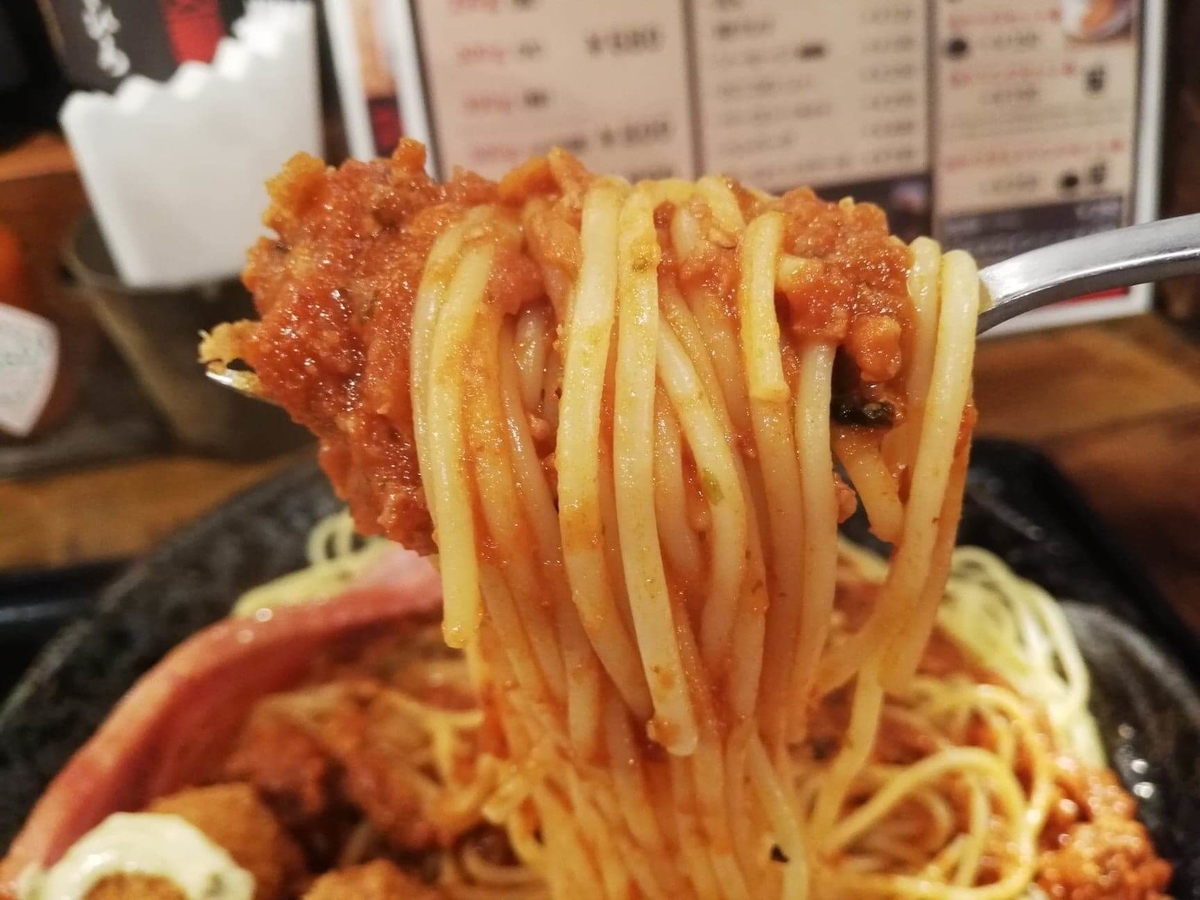 池袋『ひるだけやミート次郎』のミートソースパスタをフォークですくっている写真