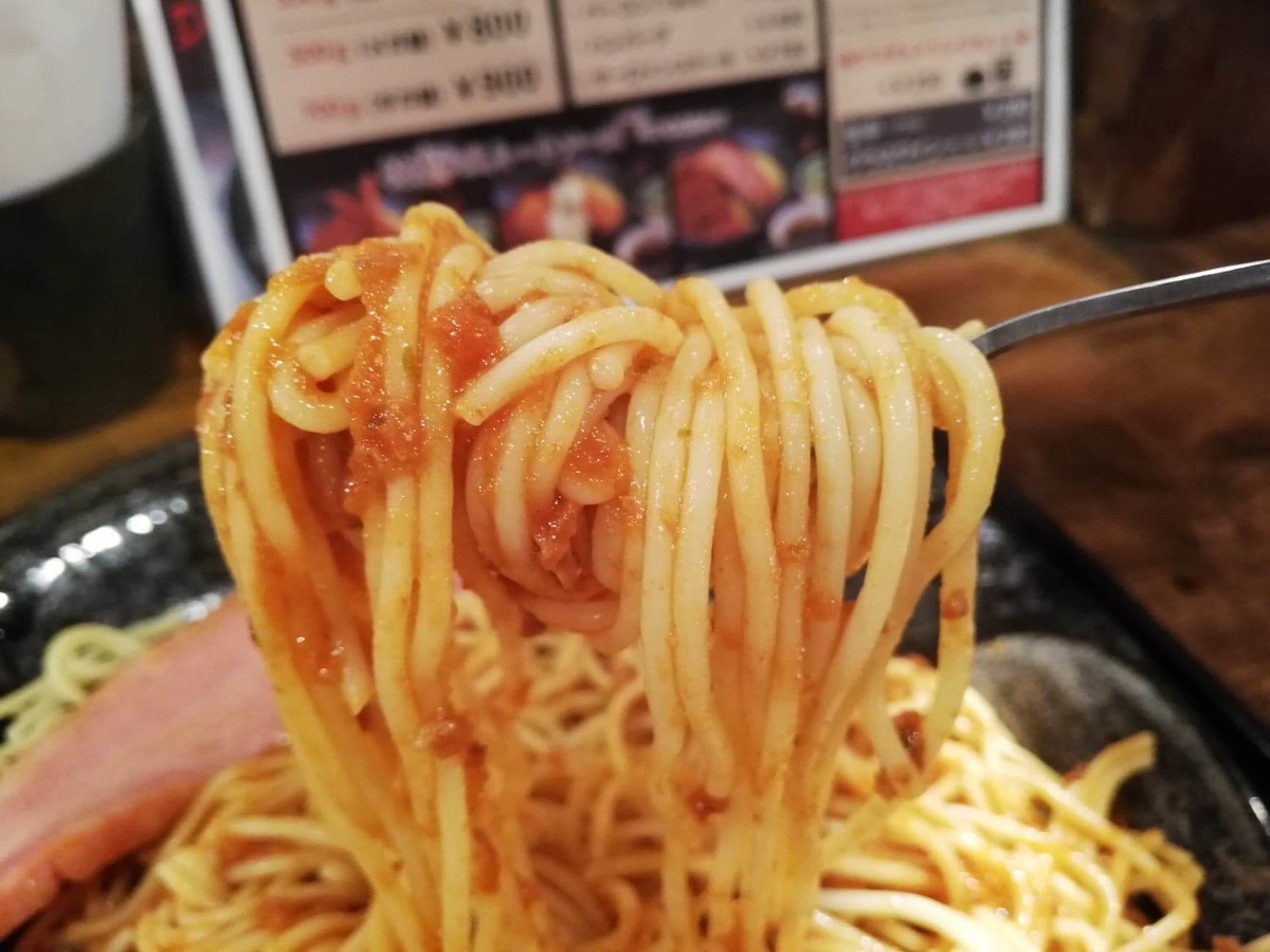 池袋『ひるだけやミート次郎』のミートソースパスタをフォークで持ち上げている写真