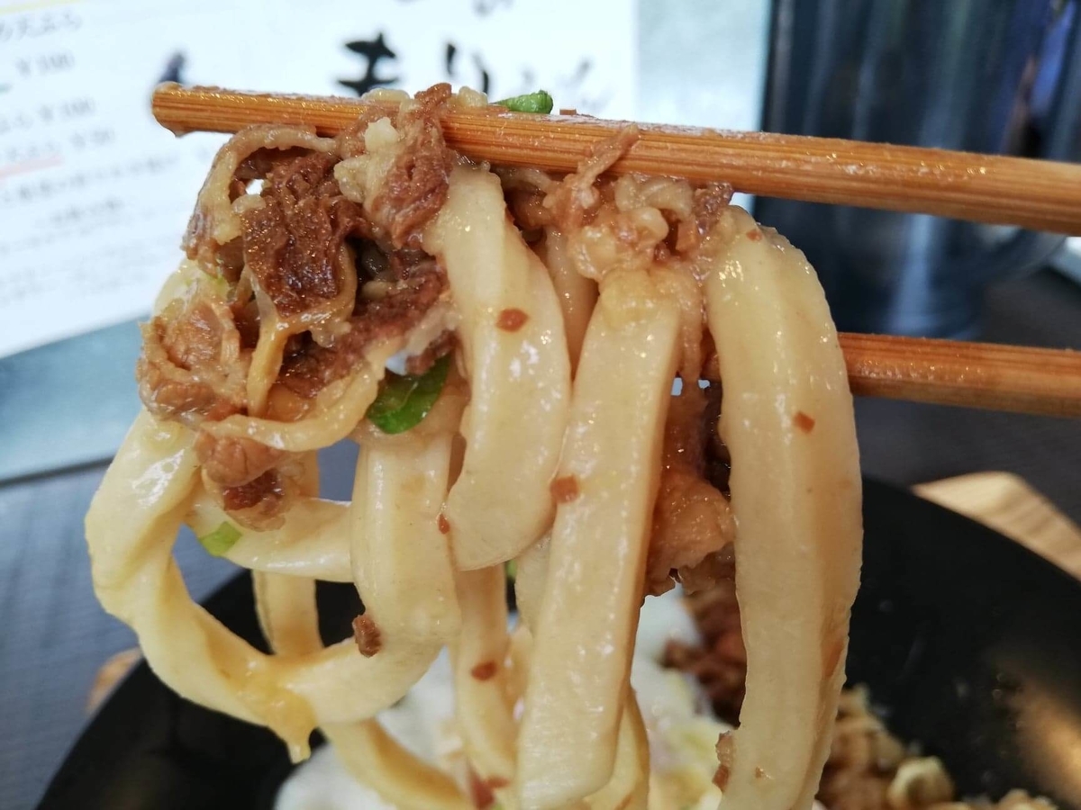 武蔵浦和(北戸田)『武蔵野うどん澤村』の牛とろぶっかけを箸で掴んでいる写真