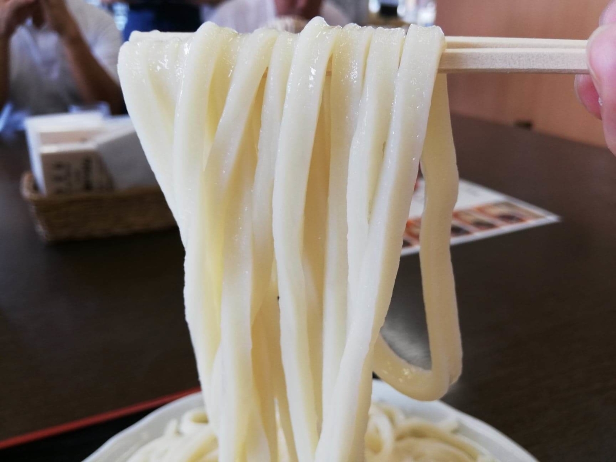 川越『藤店うどん』の肉汁うどんの麺を箸で掴んでいる写真