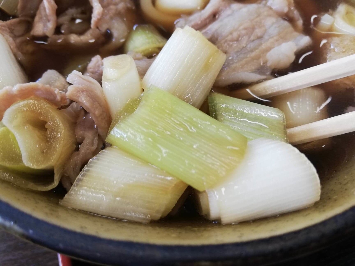 川越『藤店うどん』の肉汁うどんのスープの具材の写真