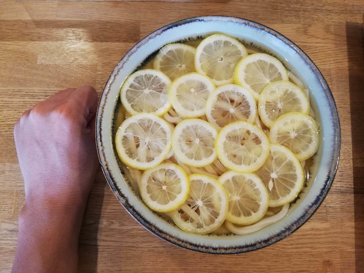 本川越『うどんとお酒土麦』の、レモンの冷かけうどんと拳のサイズ比較写真