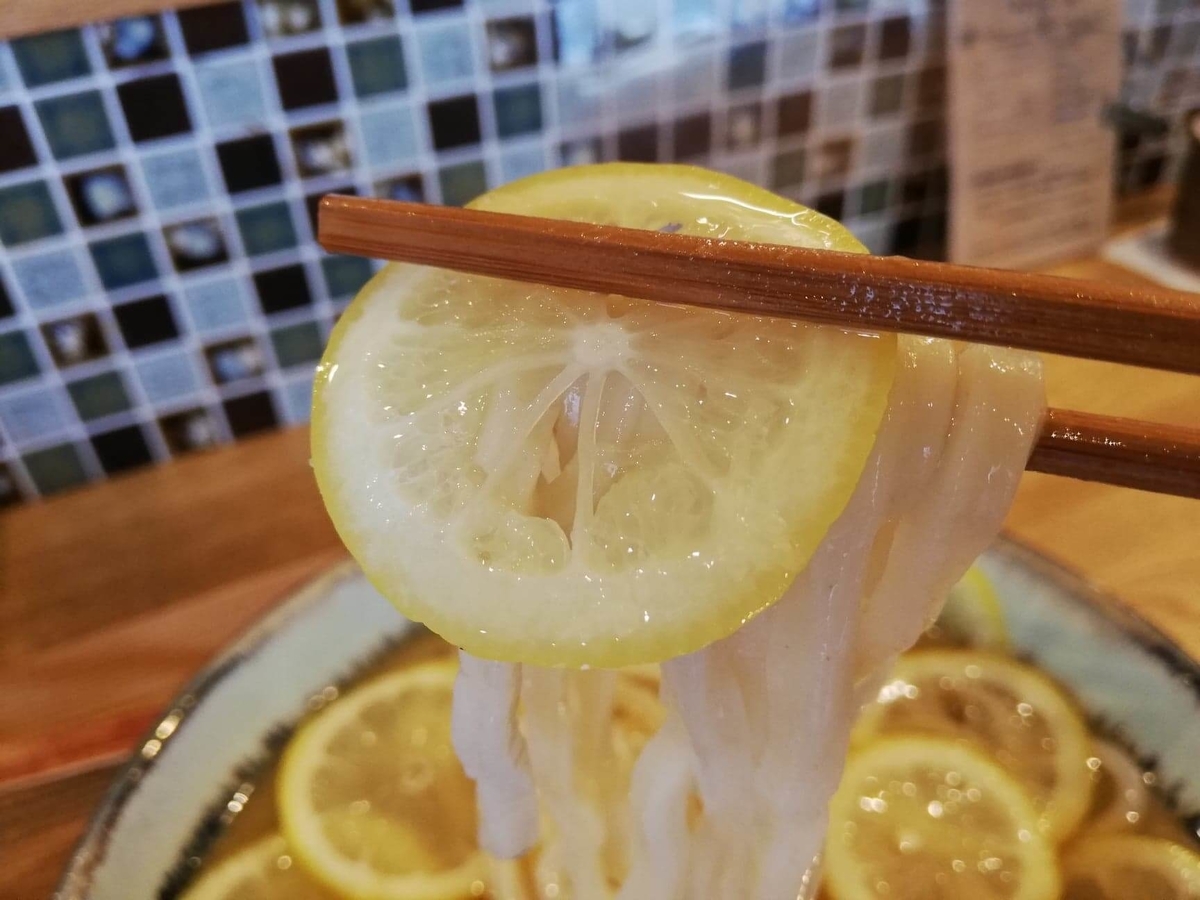 本川越『うどんとお酒土麦』の、レモンとうどんを箸で掴んでいる写真