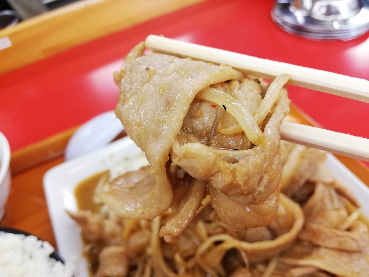 新座『くるまやラーメン』の焼肉を箸で持ち上げている写真