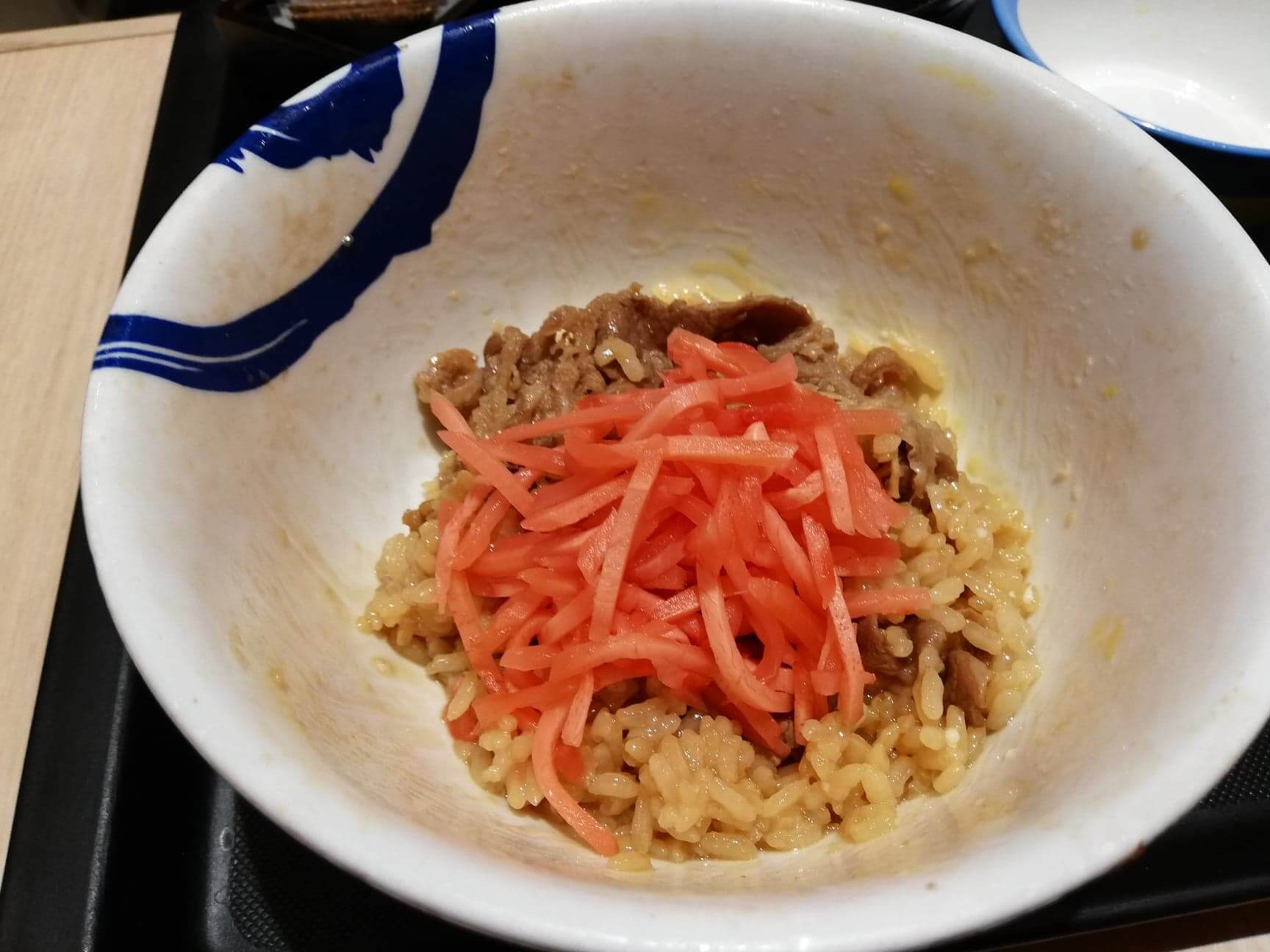 松屋の牛丼に紅生姜を乗せた写真