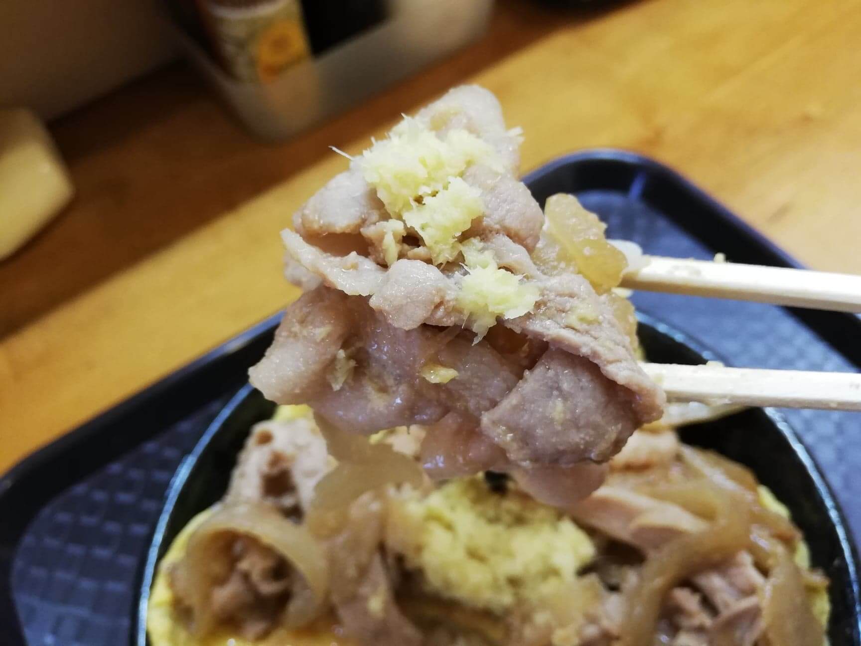 江古田『笑姜や』の、理想の生姜焼き丼を箸で持ち上げた写真