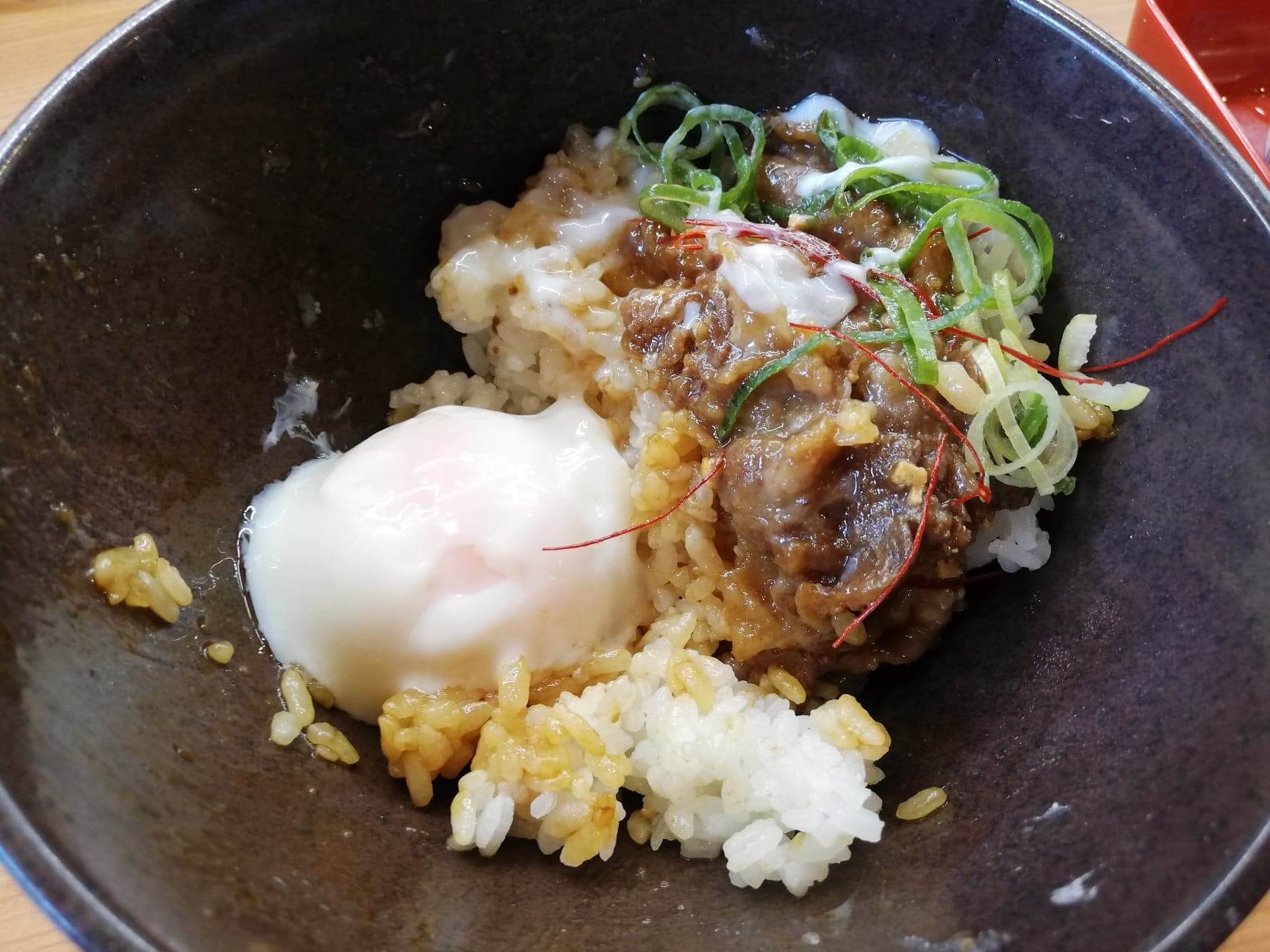 くら寿司の平日限定ランチ『牛カルビ丼ガーリック』に温泉卵を入れた写真