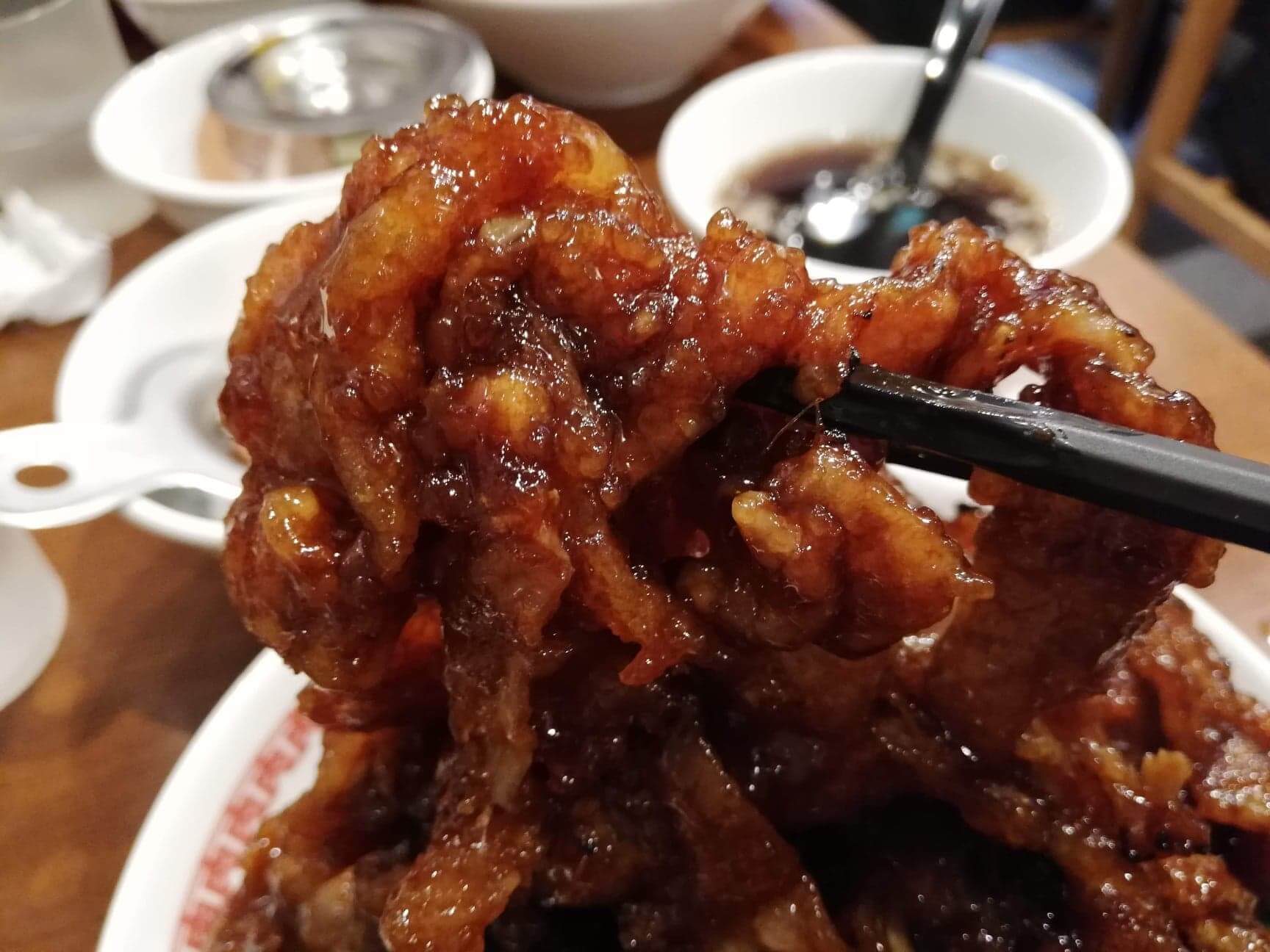 高田馬場『肉汁麺ススム』の肉汁丼の肉を箸で掴んだ写真