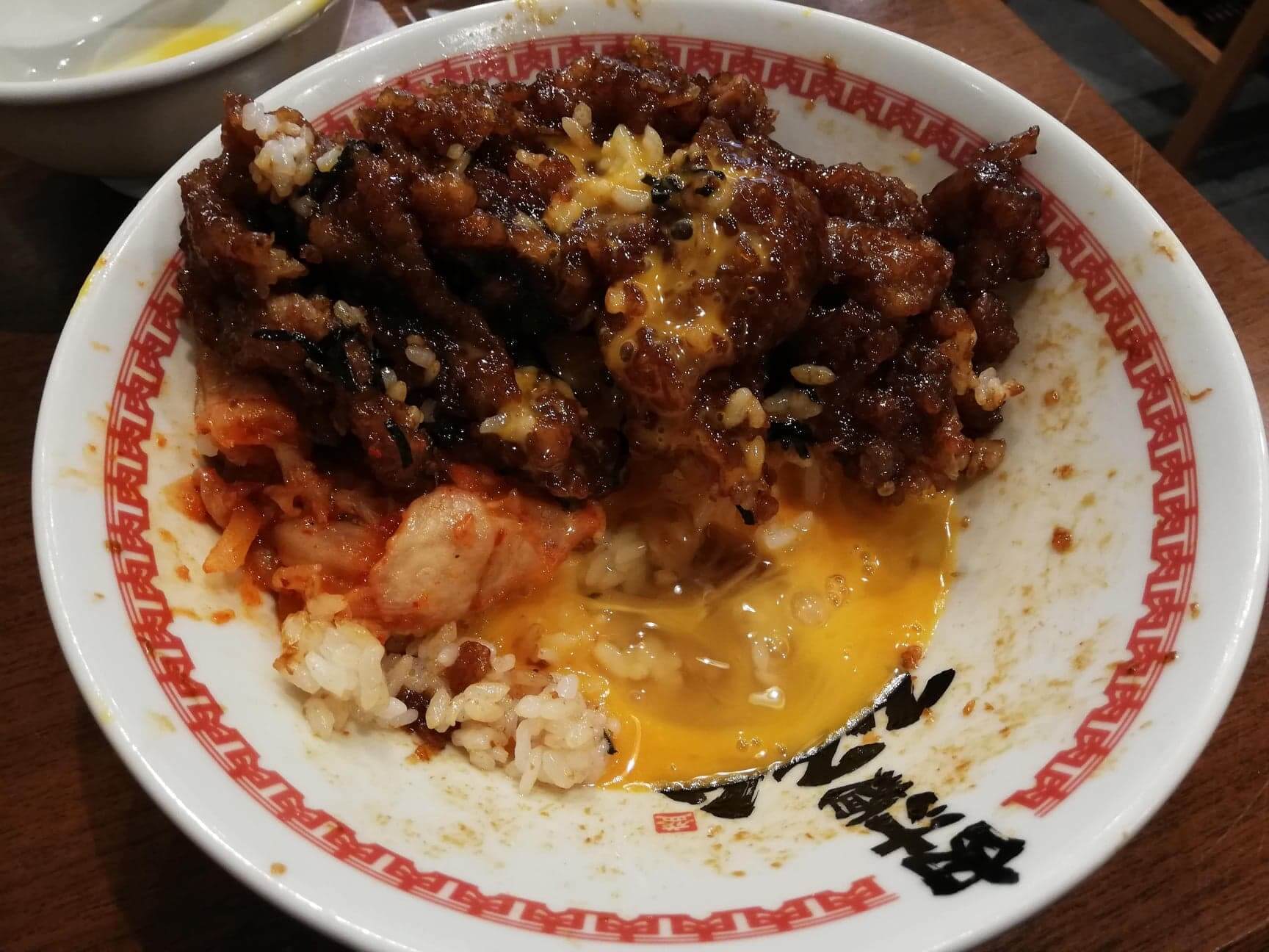 高田馬場『肉汁麺ススム』の肉汁丼と生卵の写真