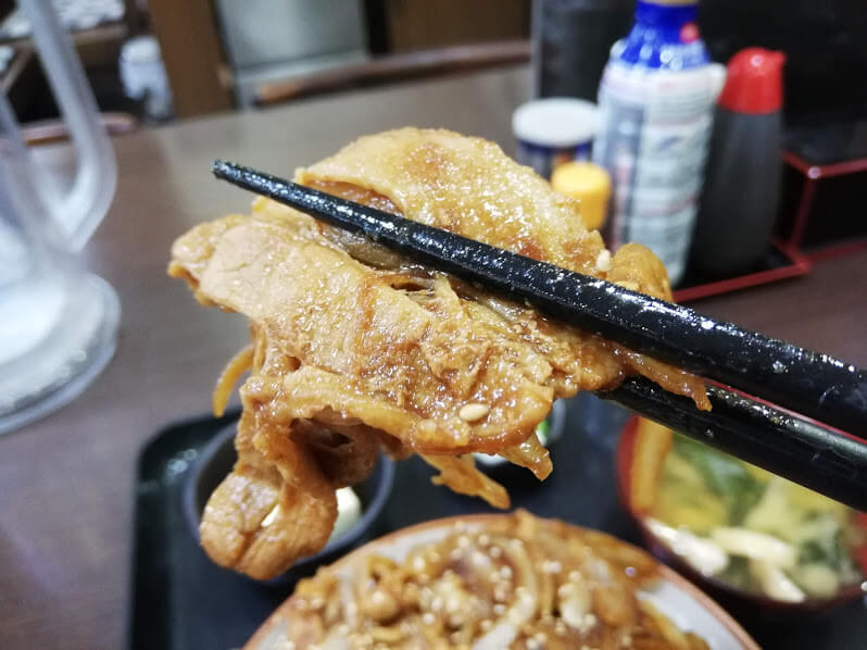 仙台『久美食堂』の焼肉を箸で掴んでいる写真