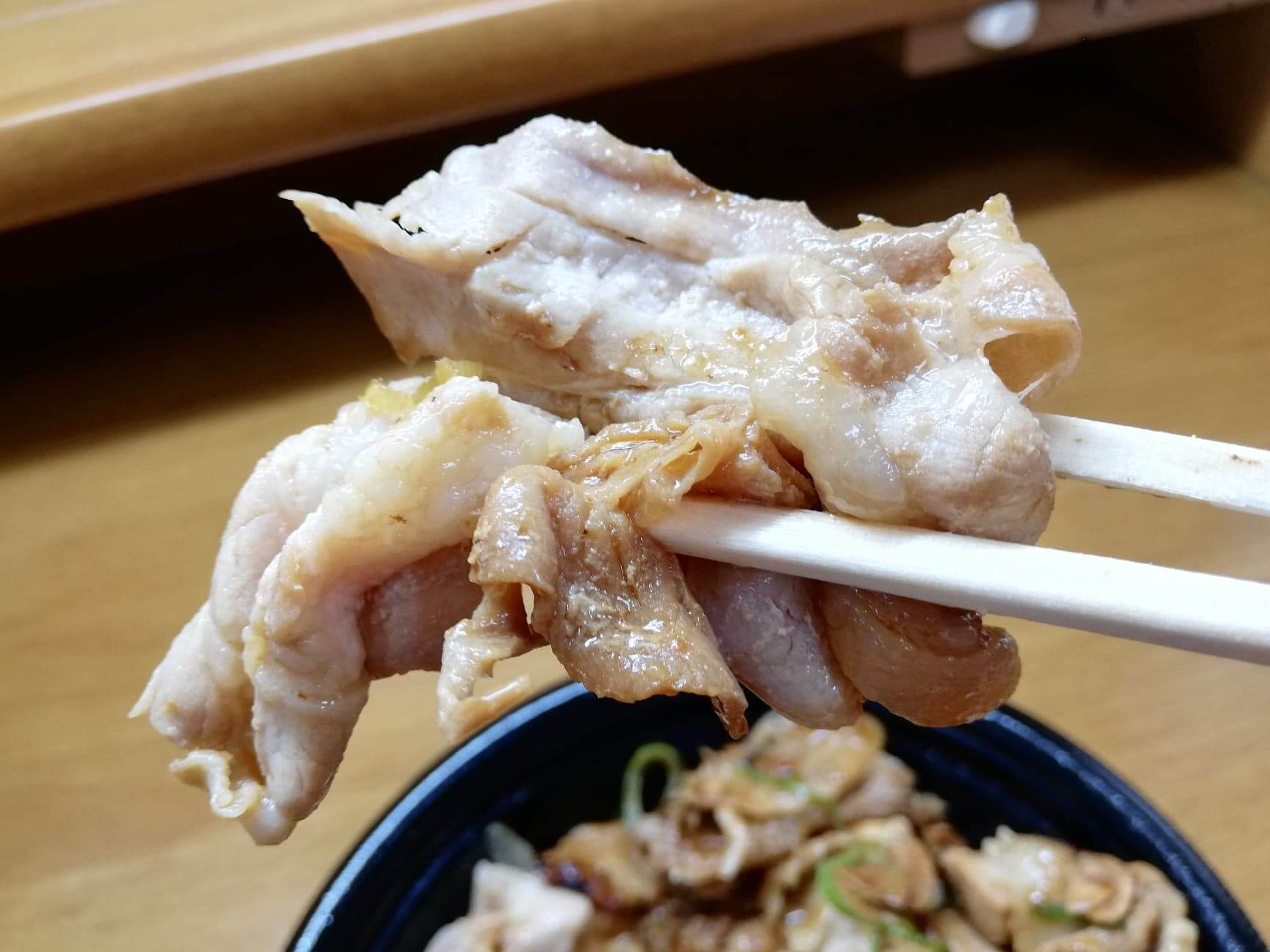 吉野家の『スタミナ超特盛丼』の肉を箸で掴んでいる写真